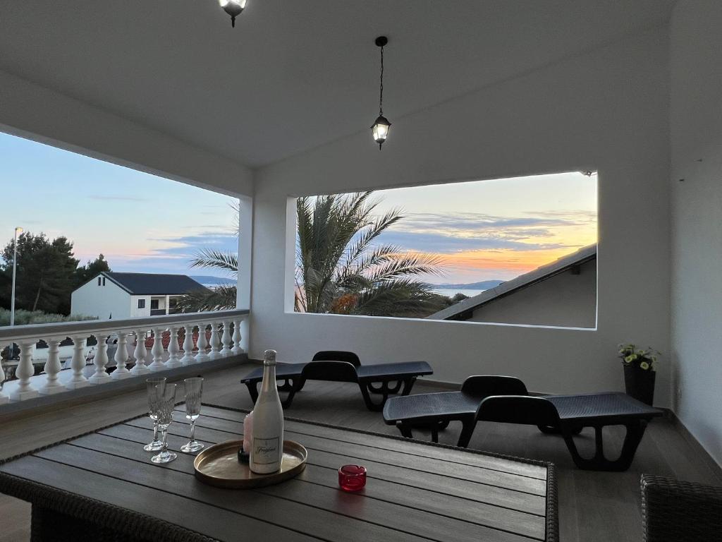 a balcony with a table and chairs and a large window at Holiday Home Marković in Bibinje