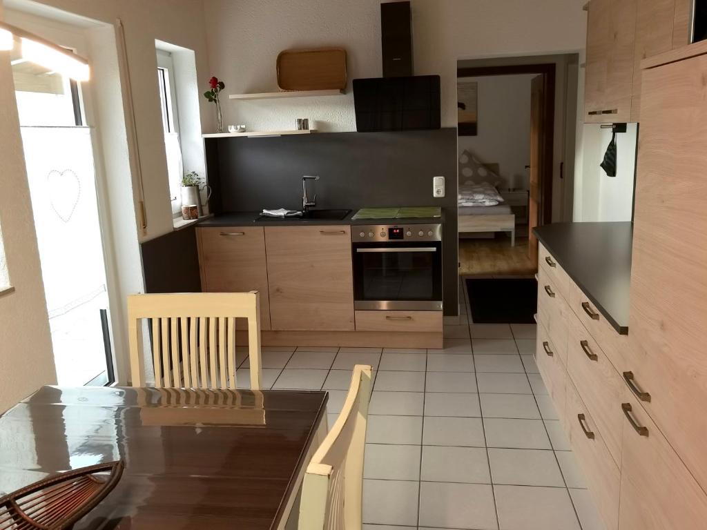a kitchen with a table and a stove top oven at Ferienwohnung Leni mit Balkon in Maroldsweisach