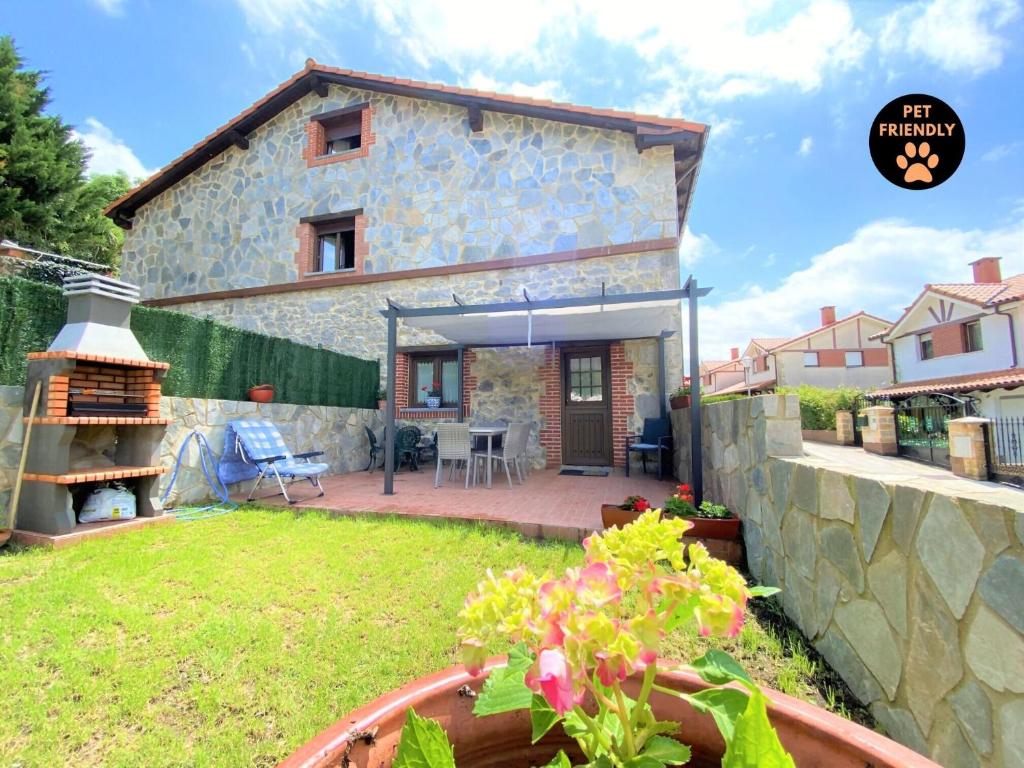 a small house with a patio and a yard at Casa Las Hortensias Hoznayo in Entrambasaguas