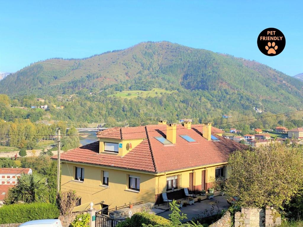 a yellow house with a mountain in the background at La Rectoral 1 Arriondas VV-1379-AS in Arriondas