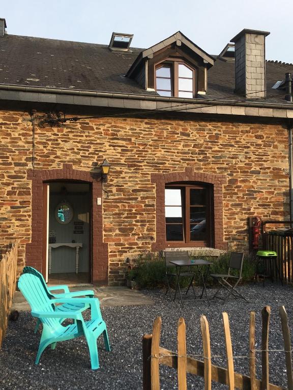 a blue chair in front of a brick building at Gite la Truite a Mouzaive in Vresse-sur-Semois