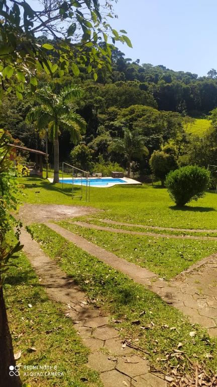 a dirt road leading into a park with a pool at Chacára Reni in Itajubá