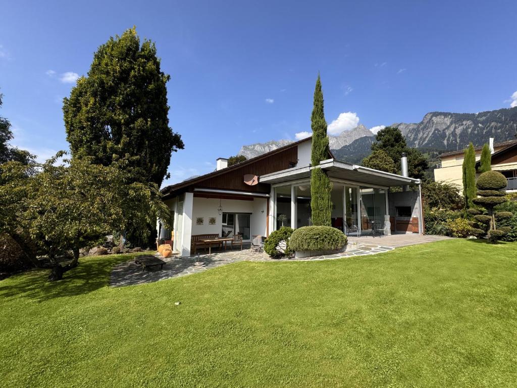 a house with a green lawn in front of it at Casa Casparis in Maienfeld