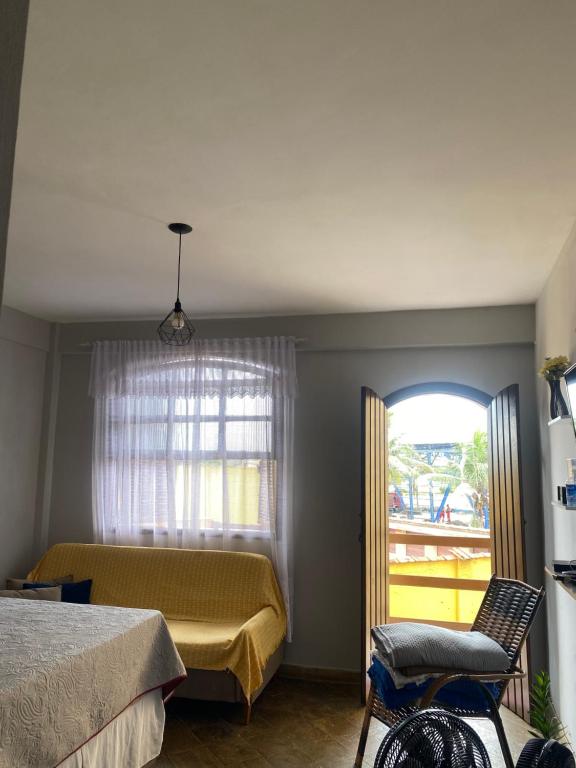 a bedroom with a bed and a window at Flat na beira da praia in Maricá