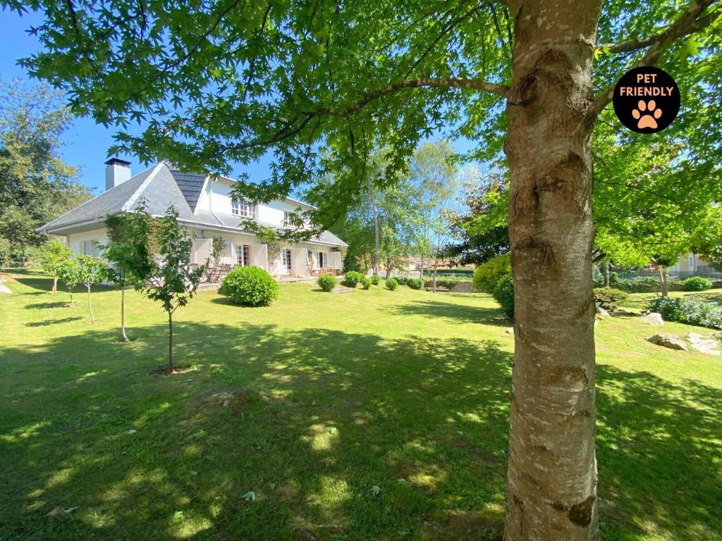 a tree in front of a house with a sign on it at Casa Vaqueiro Llanes VV-1727-AS in Llanes