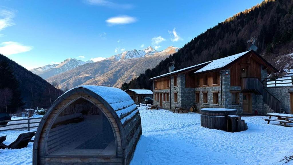 a building in the snow in front of a mountain at Chalet Les Combes in Ponte di Legno