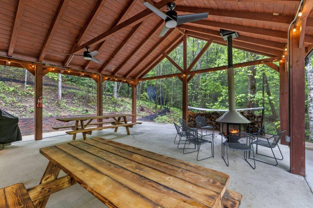 a pavilion with a wooden bench and a table at A-Frames Under the Canopy - Multi-Cabin Retreat in Pine Ridge