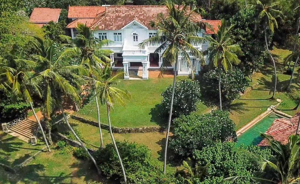 an aerial view of a house with palm trees at Villa de Zoysa Yoga, Wellness & Waves in Busse