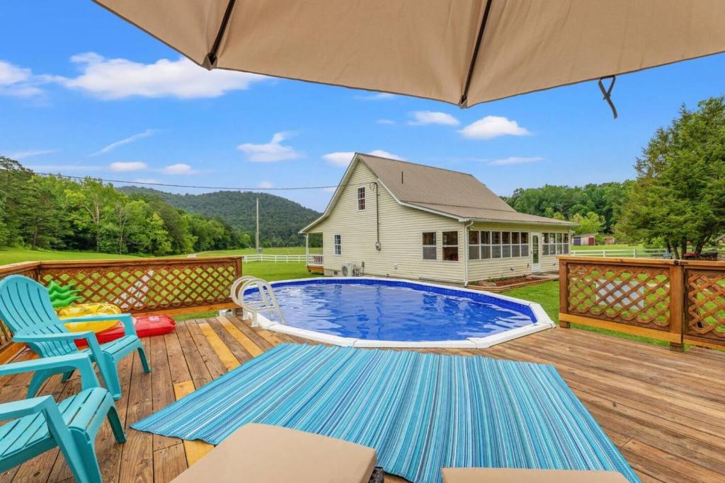 a pool on a deck with chairs and an umbrella at Hidden Treasure- Private Pool, Pond, 1600 Acres in Clay City