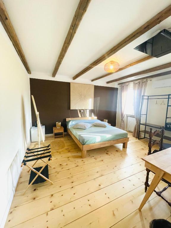 a bedroom with a bed and a wooden floor at Cà VENDALIS Agriturismo & Cantina in Cinto Euganeo