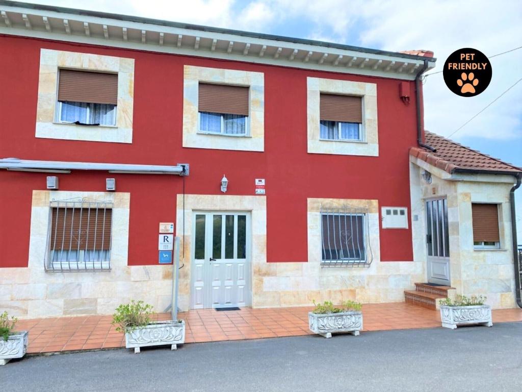 a red building with a door in front of it at Casa Noval, zona rural VV-3120-AS in Bimenes