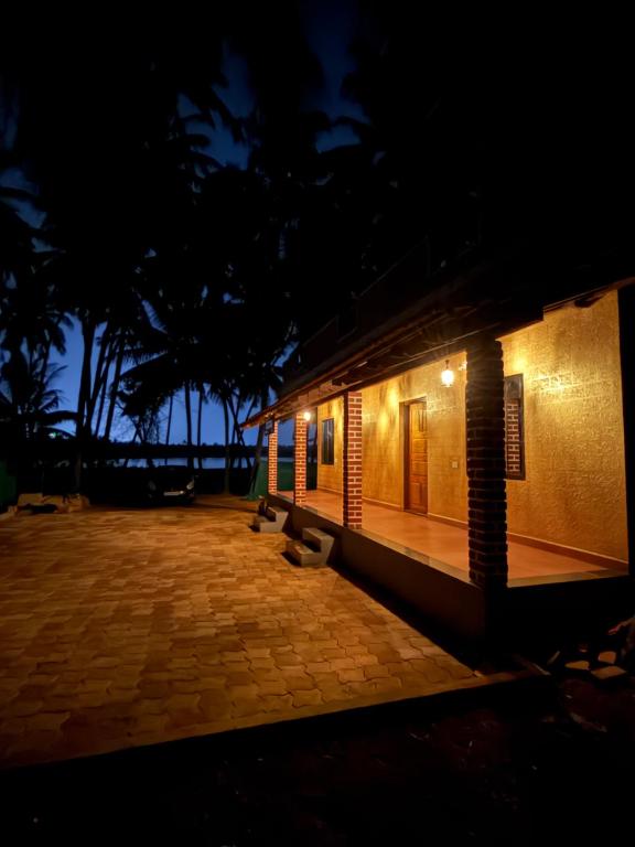 a building with a bench in front of it at night at Suraksha Homestay in Malpe