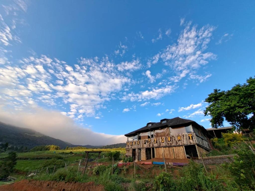 an old house in a field under a cloudy sky at Serendipity Guest Farm Byrne in Byrne
