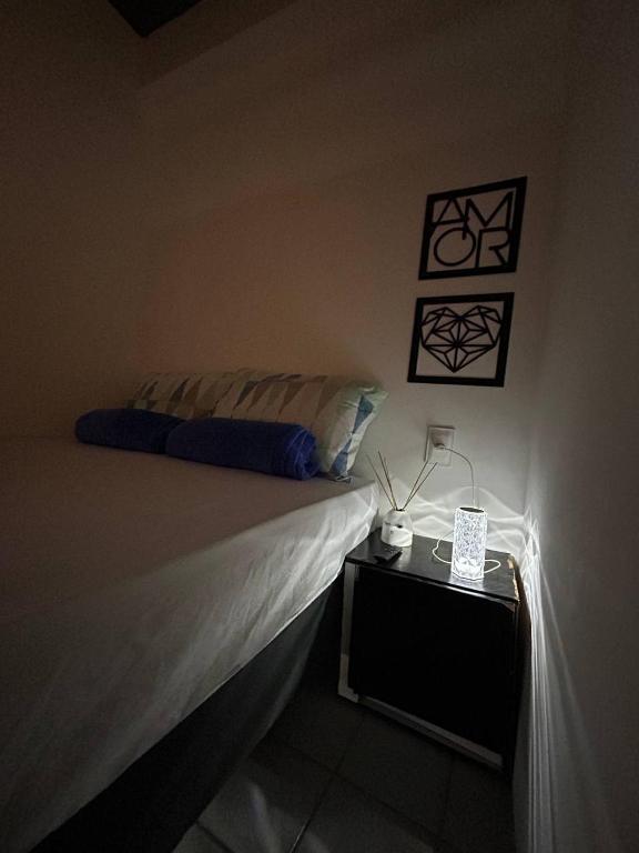 a bedroom with a bed and a night stand with a lamp at Mini Suite Comforto in Garanhuns