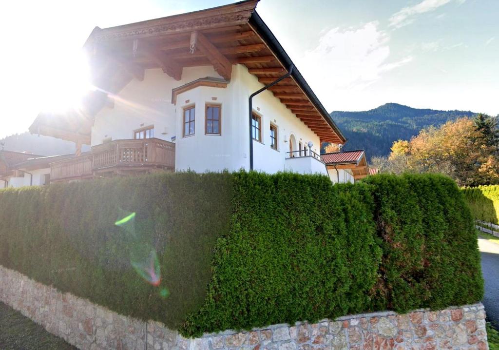 a house behind a hedge in front of a building at MountainRelaxKtzh in Kitzbühel