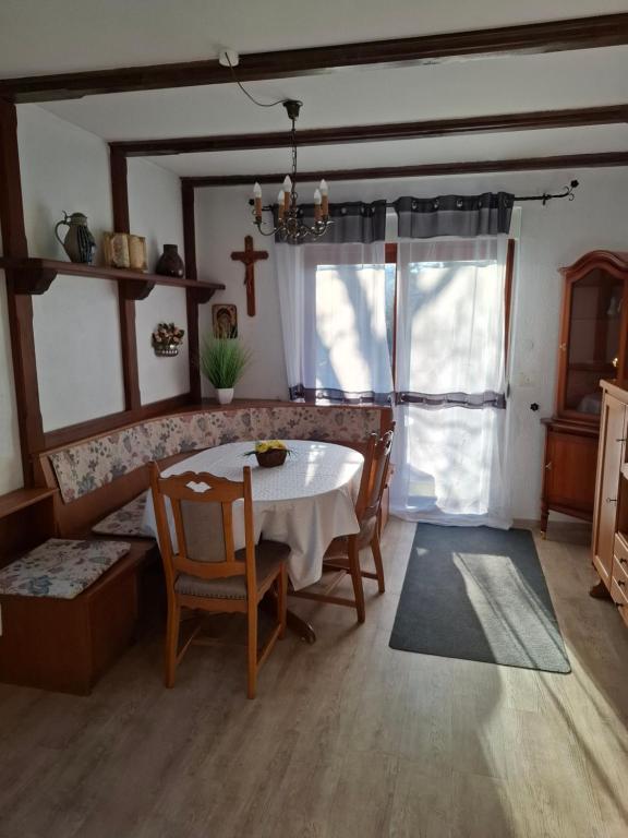 a dining room with a table and chairs and a cross at Ferienwohnung Rose in Altenkunstadt