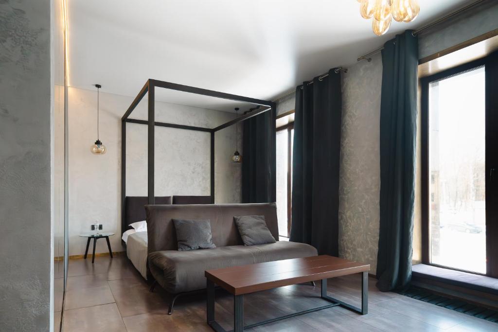 ein Schlafzimmer mit einem Bett, einer Couch und einem Tisch in der Unterkunft Sofa Boutique Hotel & SPA in Sumy