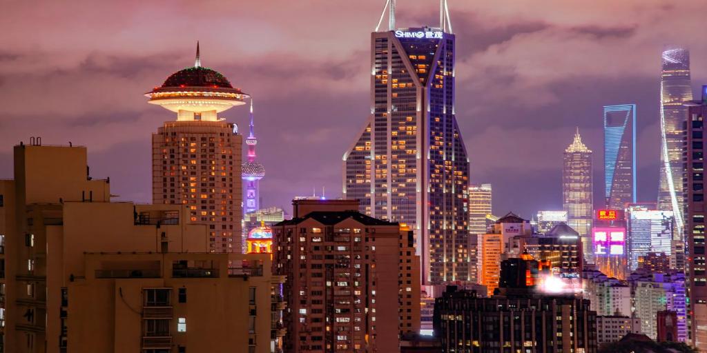 a city skyline with tall buildings at night at Uffice apartment in Shanghai