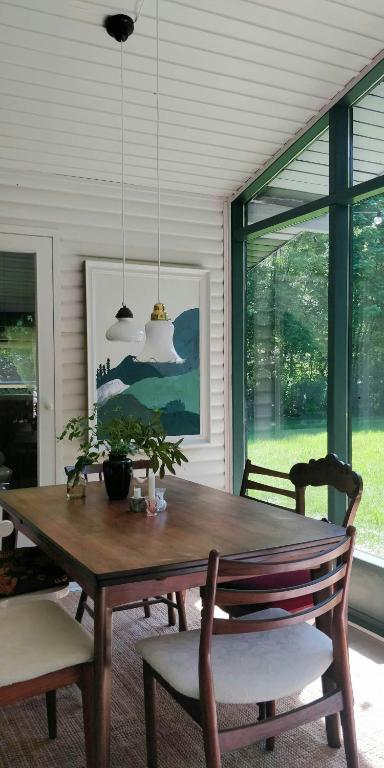 a dining room with a wooden table and chairs at Victorian Summer House On Beautiful Natural Plot in Rønde