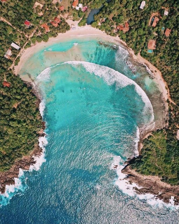 an aerial view of a beach with turquoise water at Surf Villa Hiriketiya in Hiriketiya