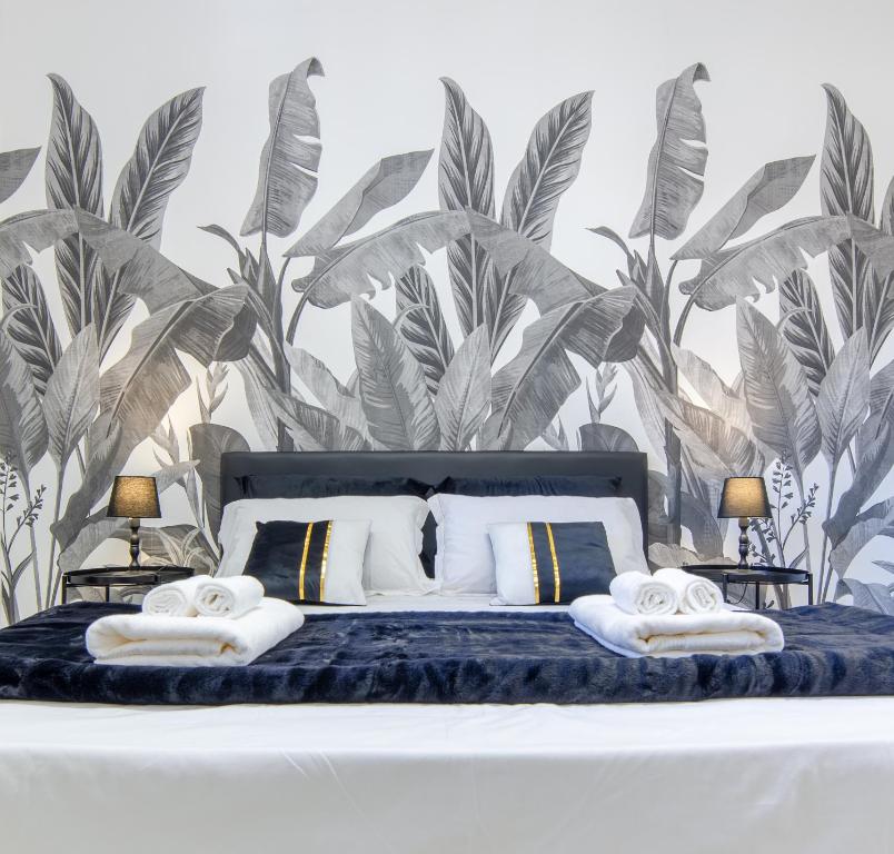 a bedroom with a bed with a tropical wallpaper at Tropical Boutique Apartment in Gallipoli