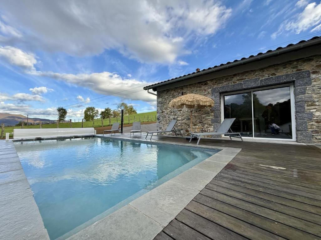a swimming pool in front of a house at Ibarnia in Suhescun