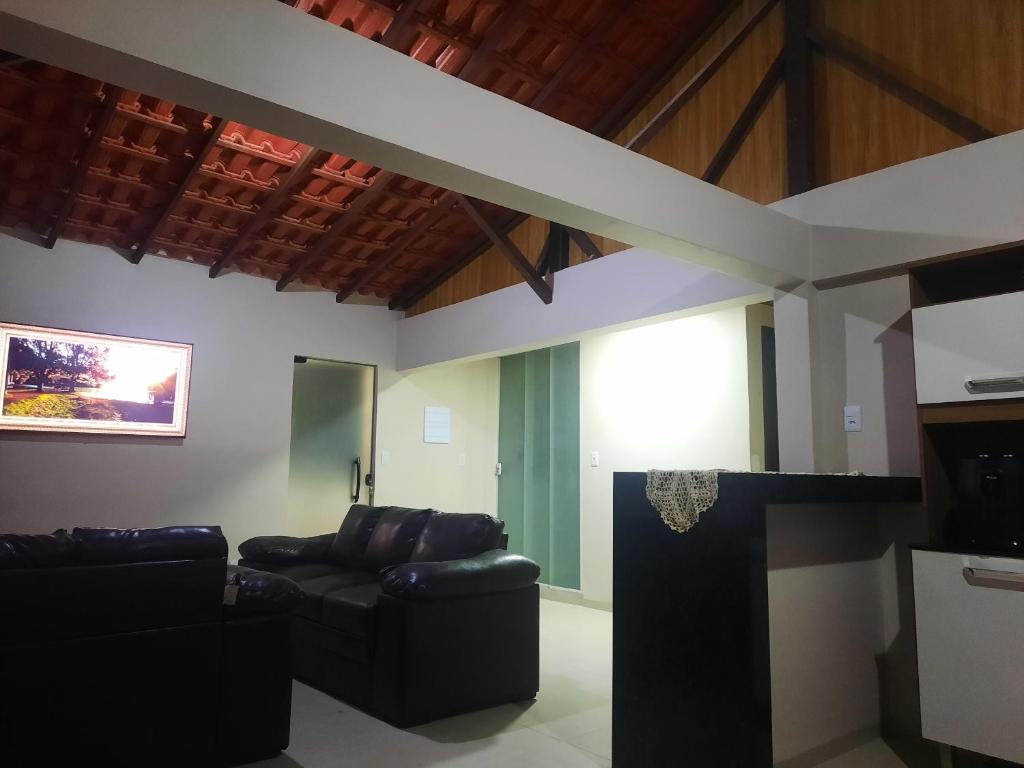 a living room with a couch and a tv at Casa - 1 Suíte e 2 Quartos in Saquarema