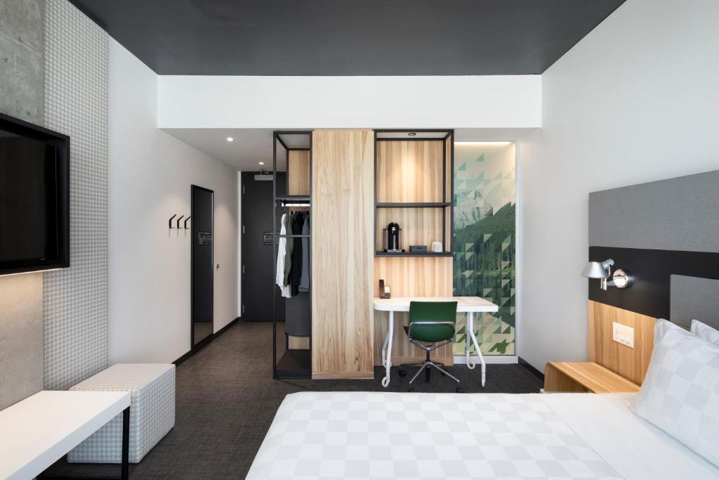 a hotel room with a bed and a desk at Alt Hotel Calgary University District in Calgary