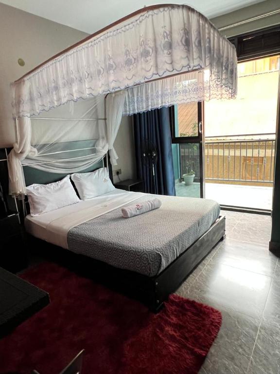 a bedroom with a large bed with a canopy at Icon Hotel in Kampala