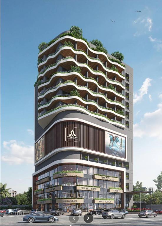 a tall building with cars parked in front of it at Hotel Presidency in Surat