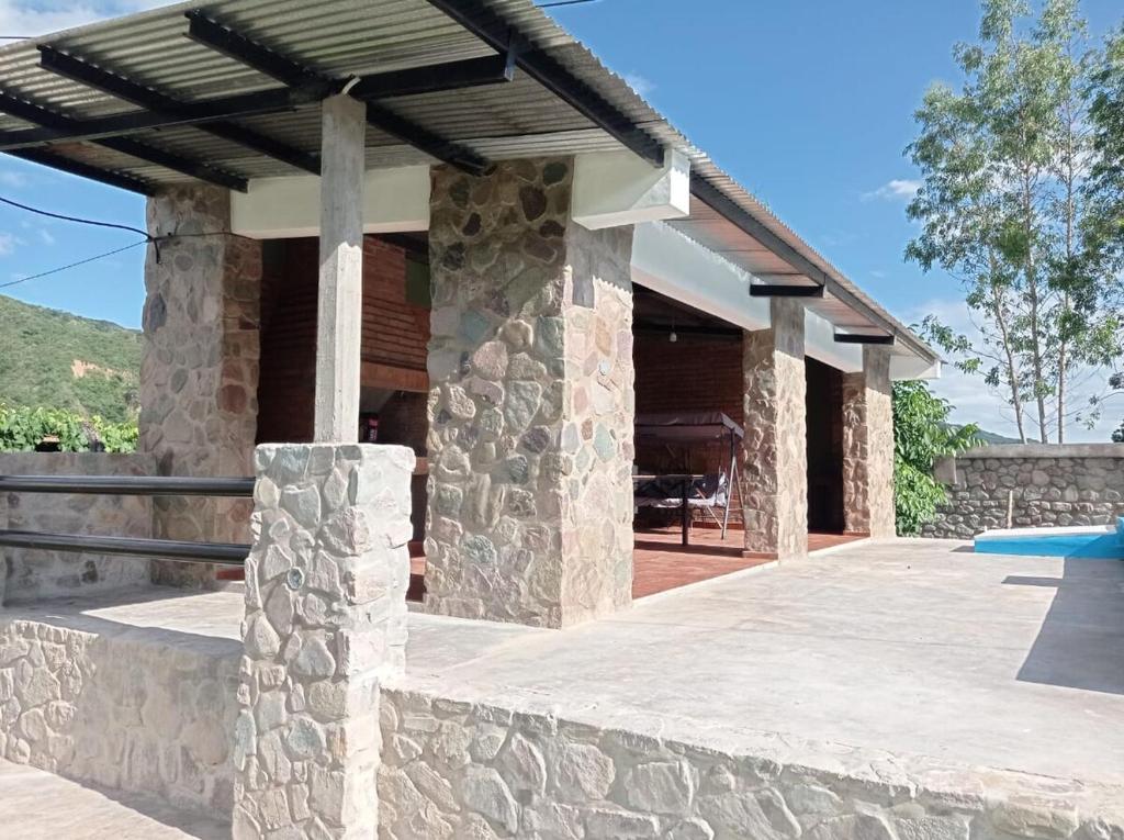 a stone house with a pool and a pavilion at Lozano Casa de Campo in Lozano