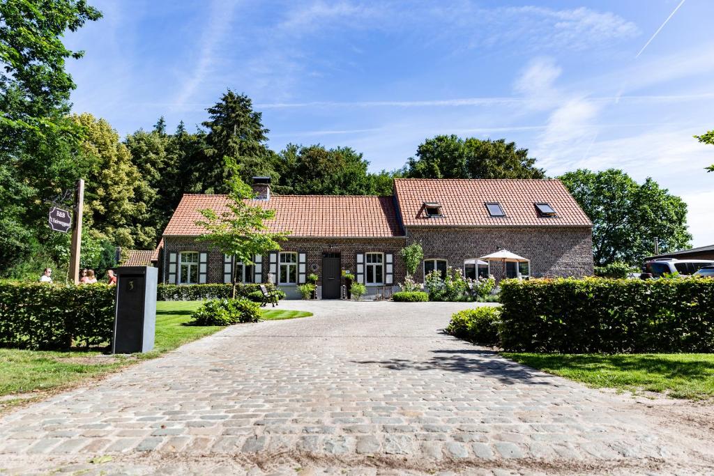a house with a brick driveway in front of it at B&B 't Heirweggoed in Assenede