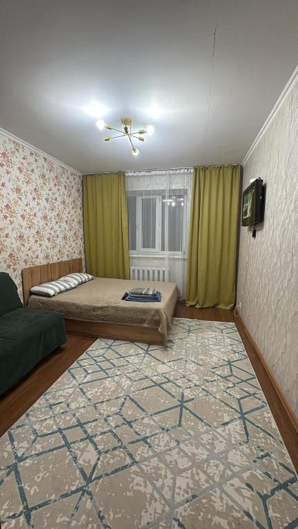a bedroom with a bed and a window and a rug at 5 минут Астана Аэропорт in Prigorodnyy
