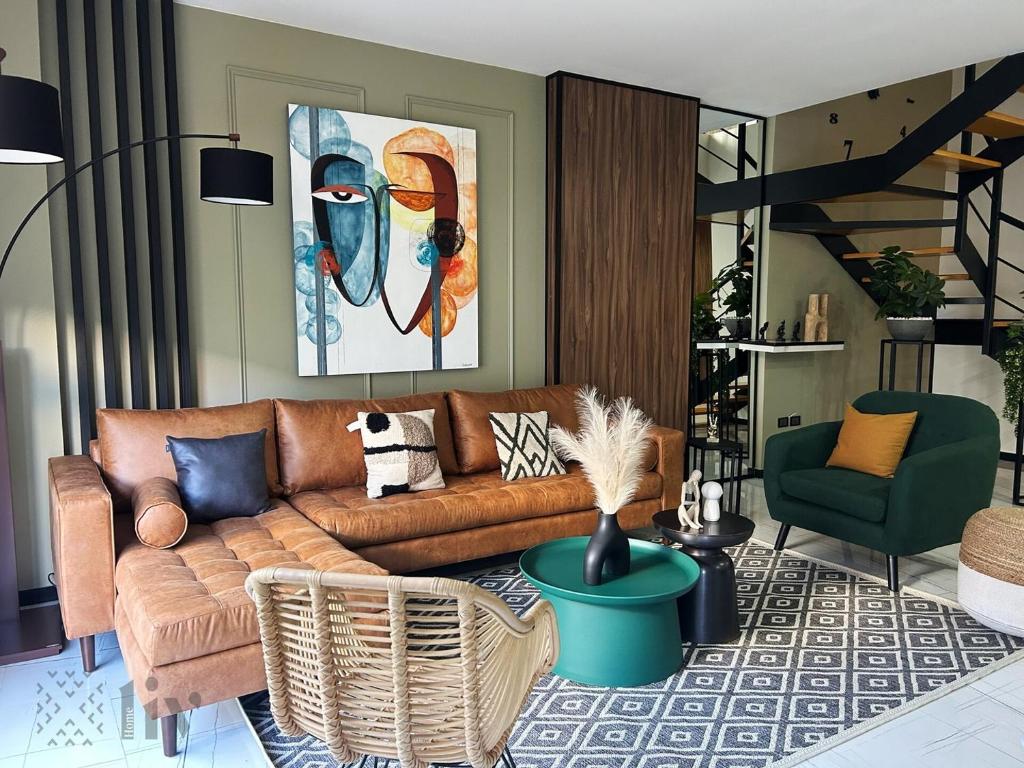 a living room with a brown couch and a green chair at Apartment home resort in La Cañada