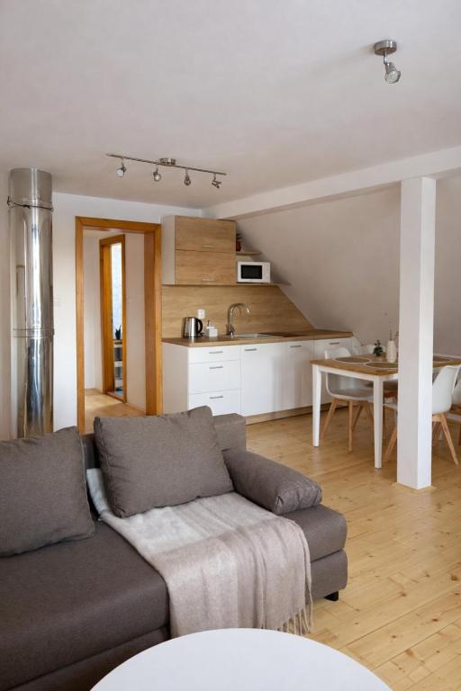 a living room with a couch and a kitchen at Pod Maliníkem in Bedřichov