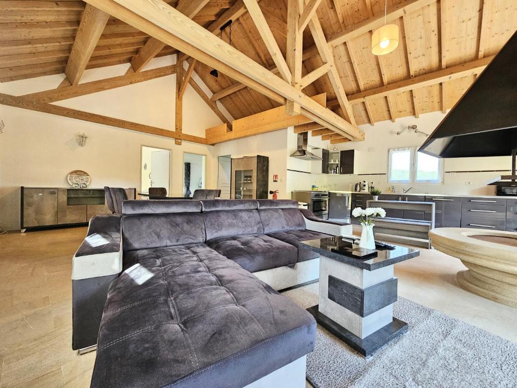 a large living room with a couch and a table at Gîte familial à Jezainville - Nature, terrasses & jardin clos, Vue vallée, forêt in Jezainville