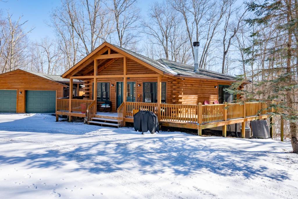a log cabin with snow on the ground at Cozy Cabin by Railey Vacations in Oakland