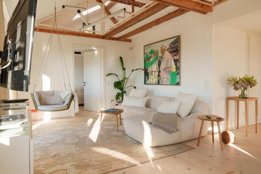 a living room with a white couch and a chair at Almhaus Kloster 38 in Kloster