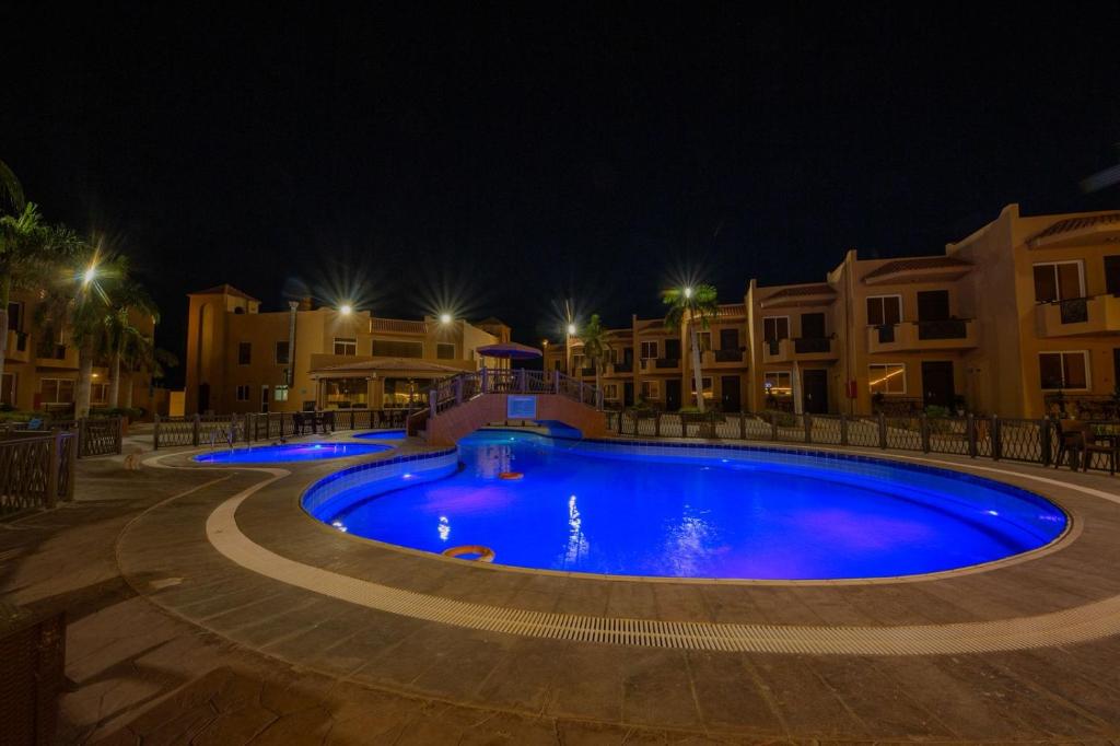a large swimming pool at night with buildings at شاليهات الأحلام لبيوت العطلات in Yanbu