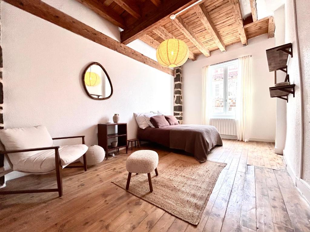 a bedroom with a bed and a chair in a room at Maison atypique - Au coeur de la vieille ville in Le Puy-en-Velay