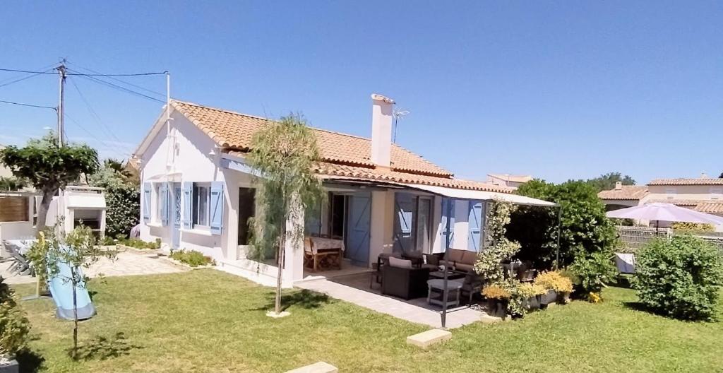 a small white house with a yard at Villa les volets bleus in Le Grau-dʼAgde
