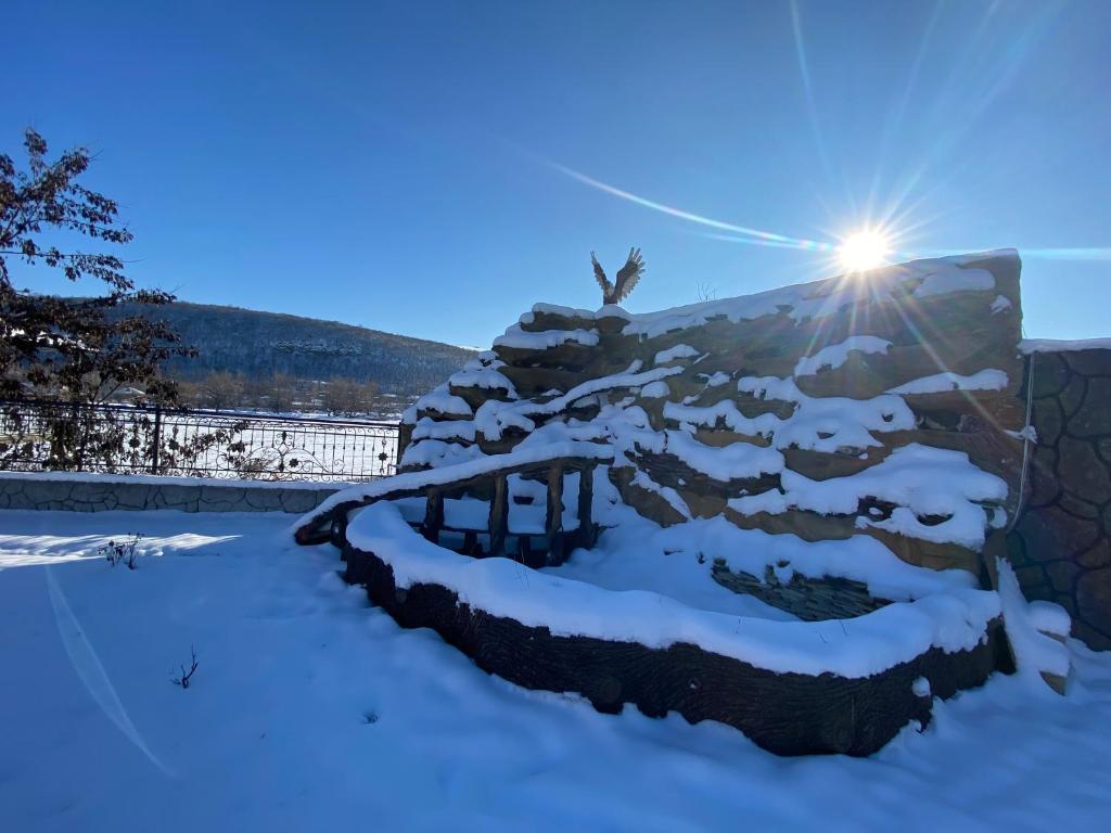 a fence covered in snow with the sun behind it at Qusar Villa in Uzunmeşǝ