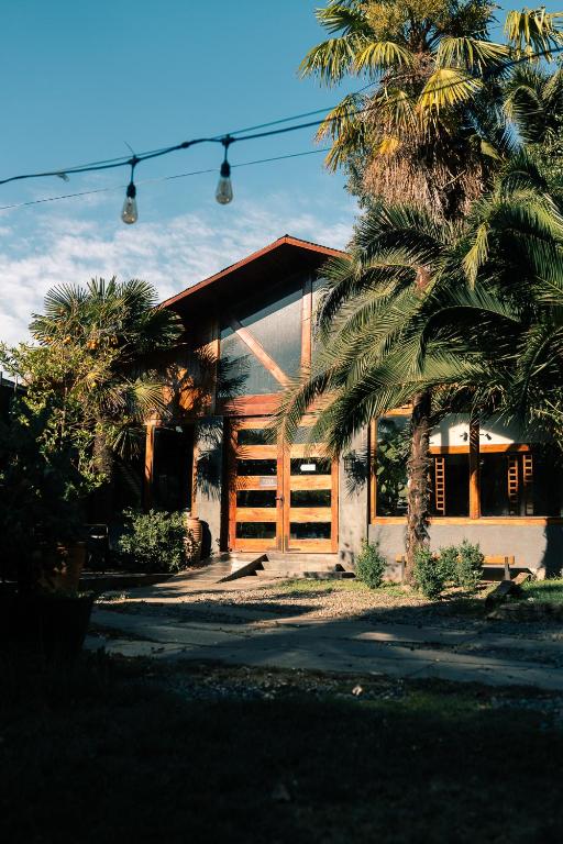 a house with a palm tree in front of it at Santa Teresita Boutique Hotel in San Fernando