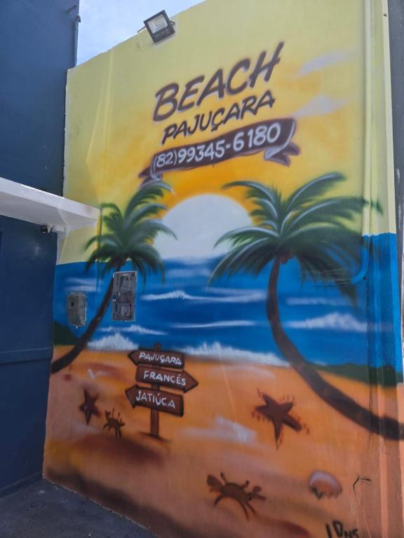 a wall with a mural of a beach with palm trees at Pousada Hostel Beach Pajuçara in Maceió