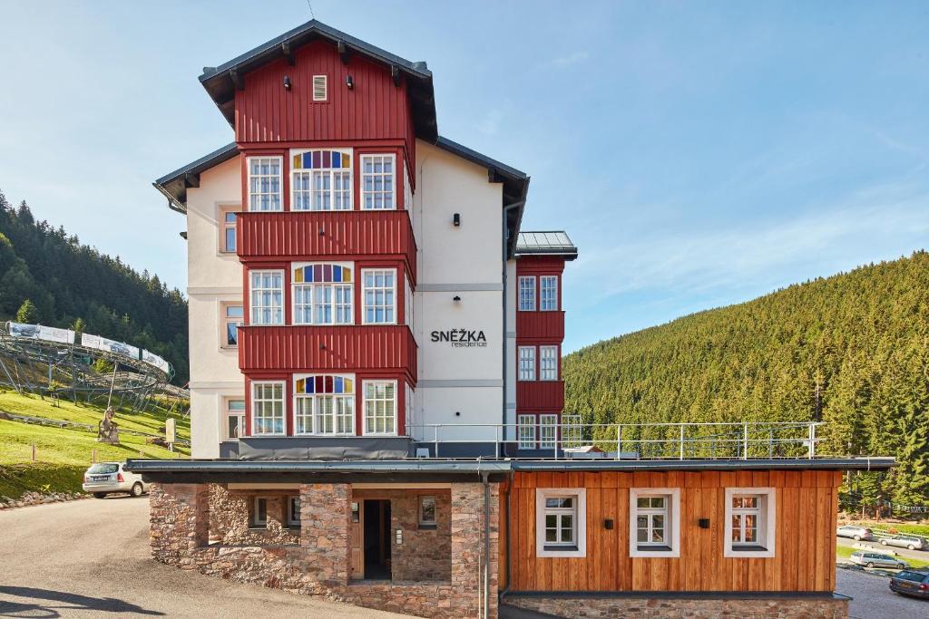 un grande edificio con rosso e bianco di Snezka Residence a Pec pod Sněžkou