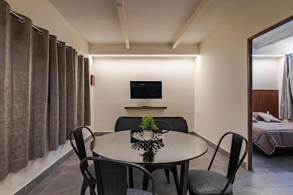 a dining room with a table and chairs and a television at Cozy condo with rooftop in Roma Norte in Mexico City