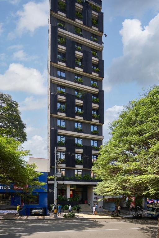 a tall black building with trees in front of it at Hunters Hotel Medellin in Medellín