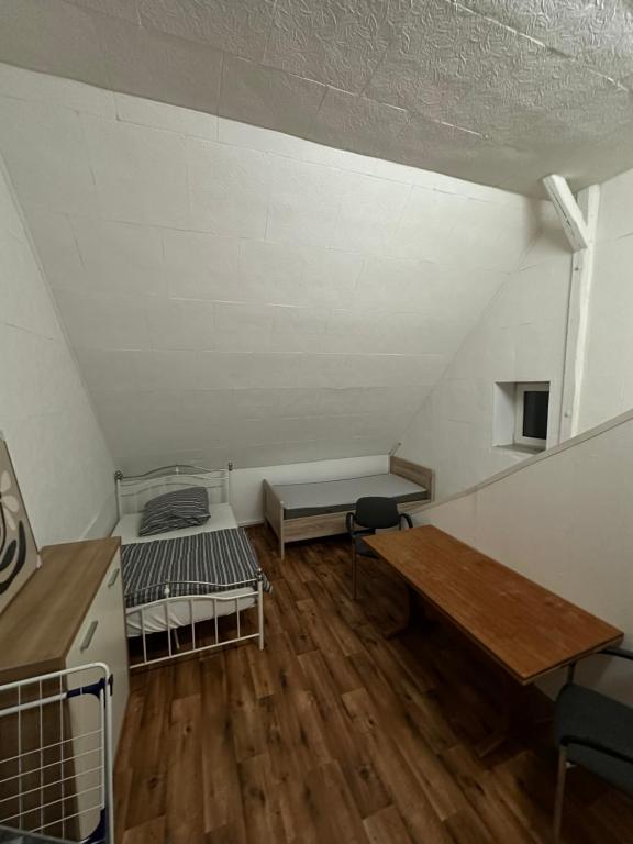an attic room with a bed and a table at Monteurwohnung, 1 Zimmer Apartment in Bad Essen