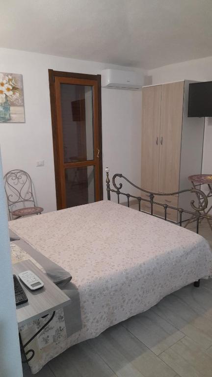 a bedroom with a bed and a table and a television at Casa Grazia Deledda 16 in Orosei