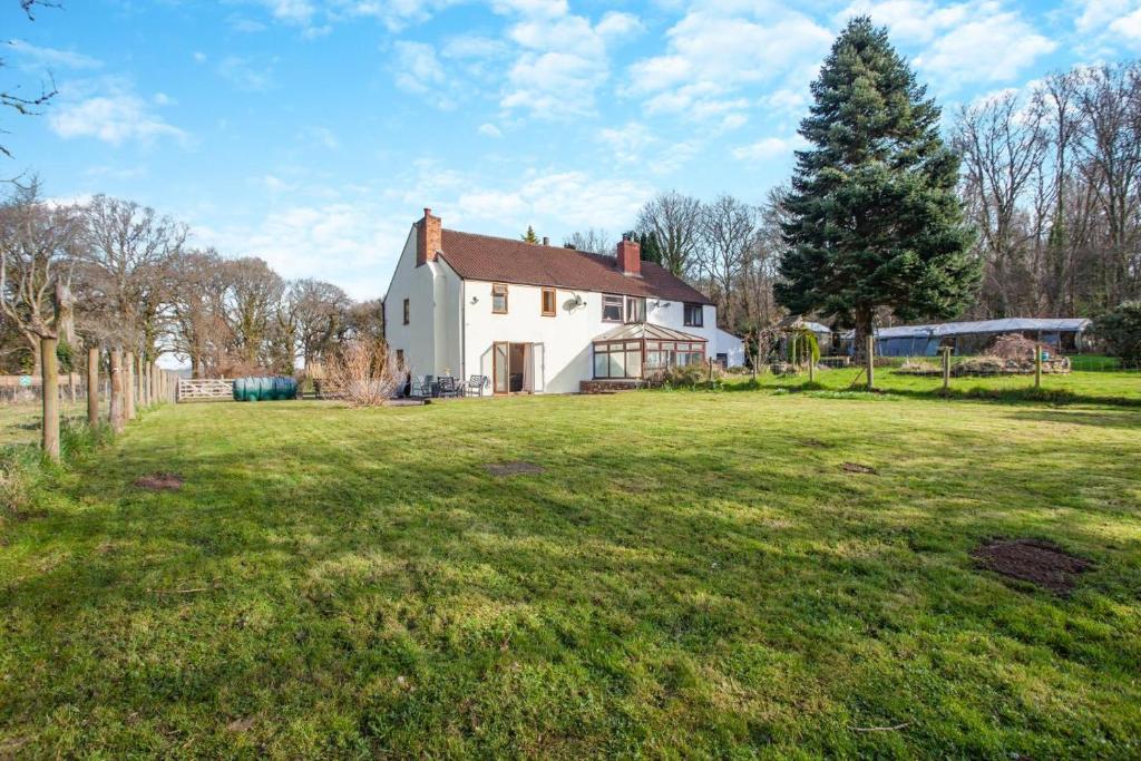 a white house in a field with a yard at 3 Bed in Littledean oc-g31084 in Little Dean